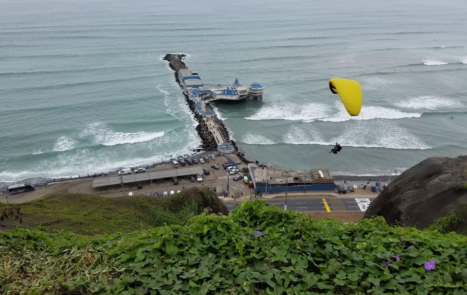 A paraglider is seen from the cliffs overlooking the Pacific Ocean in Lima's upscale neighbourhood of Miraflores, on August 20, 2016. / AFP / Daniel SLIM        (Photo credit should read DANIEL SLIM/AFP/Getty Images)