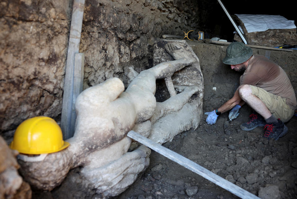 An archaeologist sits next to a marble statue, discovered at the site of the ruins of the ancient city of Heraclea Sintica, near the village of Rupite, Bulgaria, July 5, 2024. / Credit: Spasiyana Sergieva/REUTERS