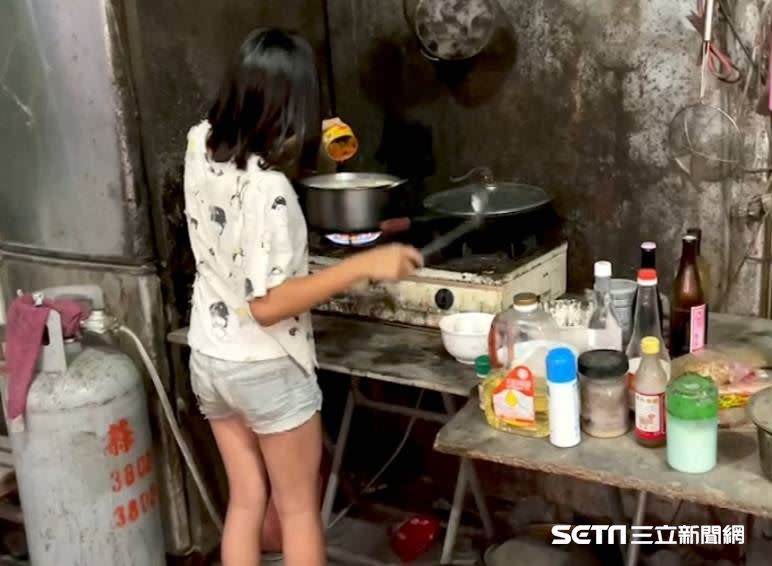 10歲大小姊姊俐落地煮飯，煮完後還得餵4歲大的妹妹吃，讓人看了佩服又心疼。（圖／台灣善種子義工團授權提供）