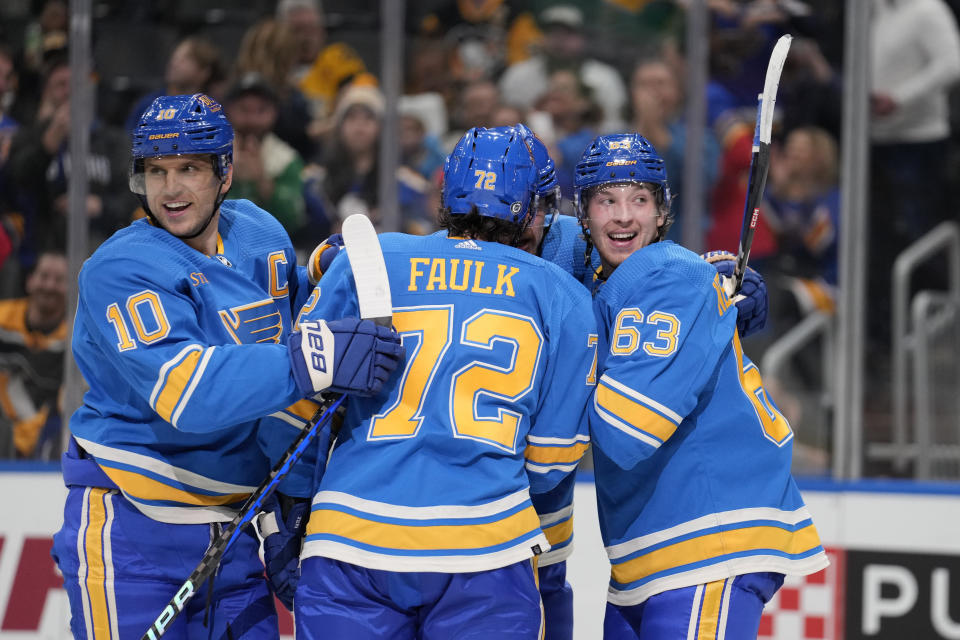 St. Louis Blues' Jake Neighbours (63) is congratulated by teammates Brayden Schenn (10) and Justin Faulk (72) after scoring during the second period of an NHL hockey game against the Pittsburgh Penguins Saturday, Oct. 21, 2023, in St. Louis. (AP Photo/Jeff Roberson)