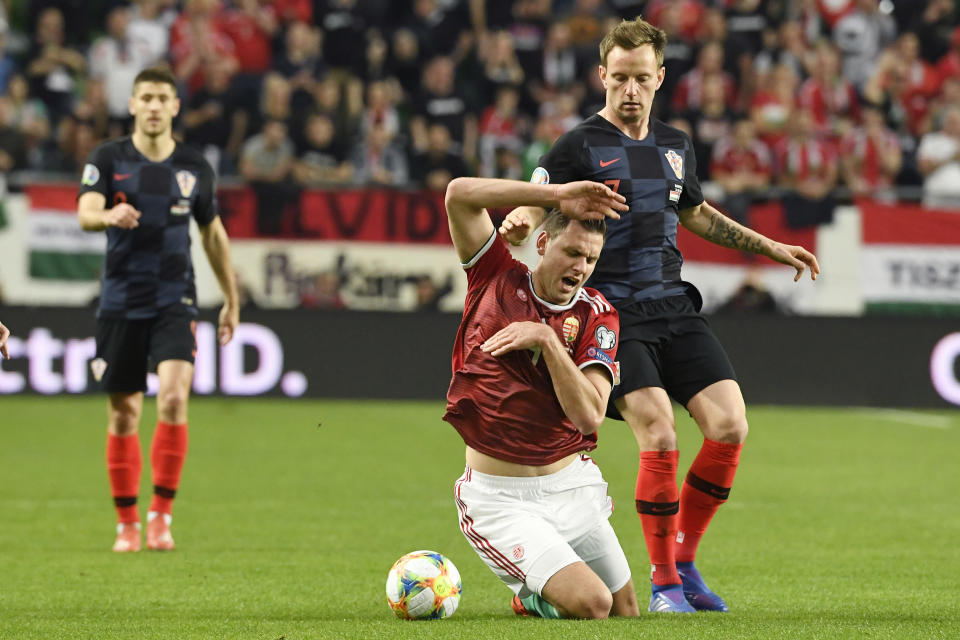 Adam Szalai, left, of Hungary and Ivan Rakitic of Croatia in action during the UEFA EURO 2020 qualifying soccer match between Hungary and Croatia in Groupama Arena in Budapest, Hungary, Sunday, March 24, 2019. (Szilard Koszticsak/MTI via AP)