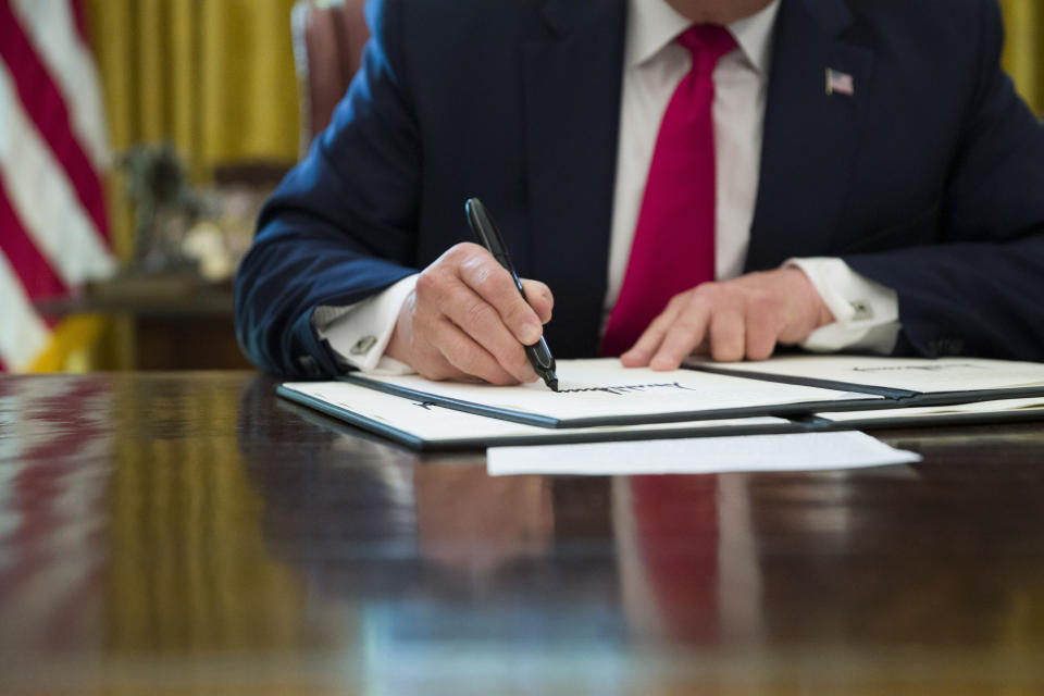 President Donald Trump signs an executive order to increase sanctions on Iran, in the Oval Office of the White House, Monday, June 24, 2019, in Washington. (AP Photo/Alex Brandon)