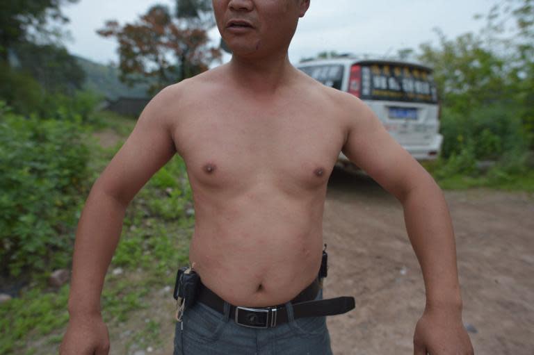 Beekeeper She Ping shows his body after it was covered in bees in southwest China's Chongqing on April 9, 2014