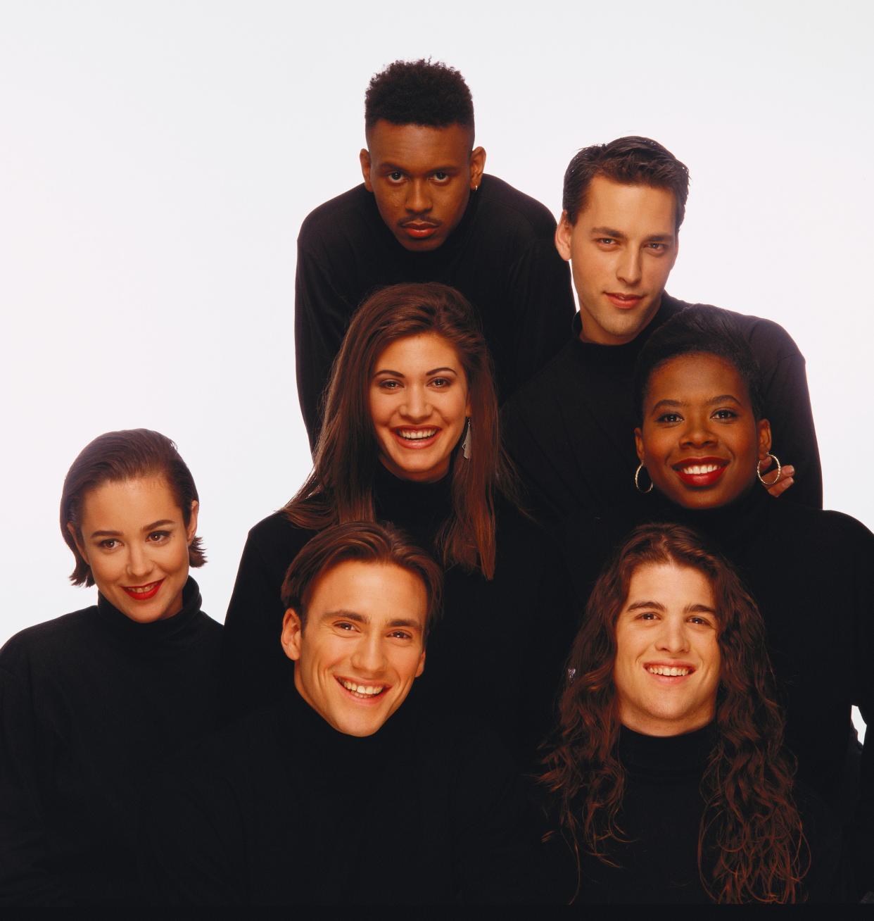 The inaugural cast of 'The Real World' - Kevin Powell, top clockwise, Norman Korpi, Heidi B. Gardner, Andre Comeau, Eric Nies, Beck Blasband and Julie Gentry, center, as seen in 1992, reunites in 'The Real World Homecoming: New York" on Paramount+.