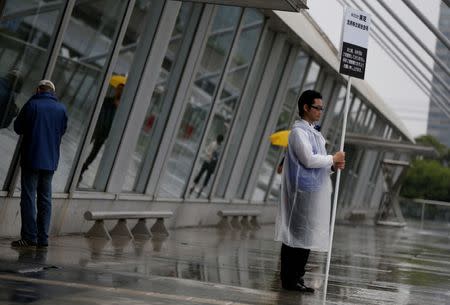 A staff member of Toshiba Corp. holds a sign board of the company's annual shareholders meeting at an entrance of the venue in Chiba, Japan June 28, 2017. REUTERS/Issei Kato