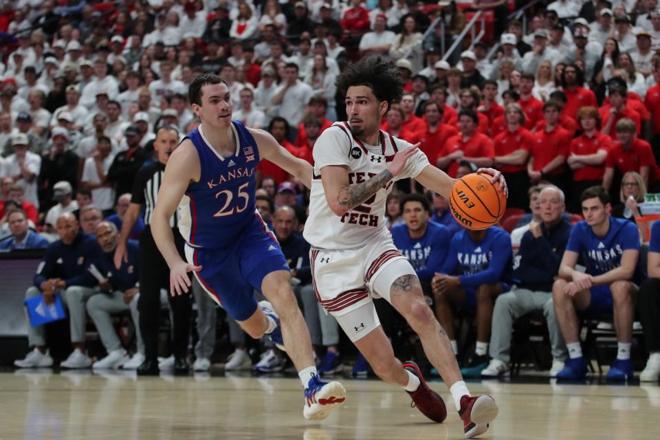 Texas Tech guard Pop Isaacs (2) drives to the lane against Kansas guard Nicolas Timberlake (25) in the first half at United Supermarkets Arena.