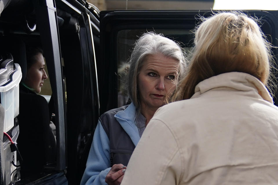 Jessie Blanchard talks with a participant near her jeep, outside of a motel where she hands out goods like Naloxone, tourniquets, needles, food, and other materials to help the community on Monday, Jan. 23, 2023, in Albany, Ga. (AP Photo/Brynn Anderson)