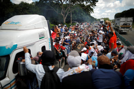 Los migrantes centroamericanos, que forman parte de una caravana de personas que intenta llegar a Estados Unidos, intentan detener un camión a lo largo de la carretera mientras continúan su viaje en Tapachula, México, 22 de octubre de 2018. REUTERS/Ueslei Marcelino