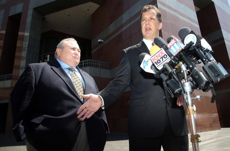 Former Bell city manager Robert Rizzo, left, and his attorney, James Spertus take questions from the media, as they leave the Edward R. Roybal Federal building and United States courthouse Monday, April 14, 2014. Rizzo was sentenced to 33 months in prison for income tax evasion on Monday. On Wednesday Rizzo faces sentencing in state court on 69 counts of fraud, misappropriation of public funds and other charges for his role in the Bell scandal. He pleaded no contest in that case in October. (AP Photo/Nick Ut)