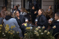 FILE - In this Wednesday, April 8, 2020 file photo people chat and drink outside a bar in Stockholm, Sweden. Sweden's relatively low-key approach to coronavirus lockdowns captured the world's attention when the pandemic first hit Europe. But it also had a per capita death rate much higher than other Nordic countries. Now, as infection numbers surge in much of Europe, Sweden has some of the lowest numbers of new cases and there are only 14 people being treated for the virus in intensive care in the country of 10 million.(AP Photo/Andres Kudacki, File)