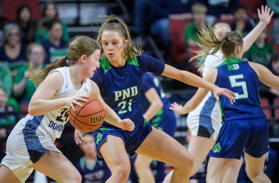 Peoria Notre Dame's Kaitlin Cassidy (21) defends against Wilmette Regina Dominican's Maddie Witchger in the first half of their Class 2A girls basketball state semifinal Thursday, Feb. 29, 2024 at CEFCU Arena in Normal. The Irish routed the Panthers 71-25.