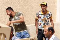 FILE - In this Monday, June 4, 2018 file photo, Tunisian men react as they wait for news of friends and relatives after the sinking of a boat carrying migrants the previous day, in the coastal city of Sfax, Tunisia. The number of Tunisians migrating clandestinely to Italy has risen to levels not seen since the 2011 Arab Spring uprising. That's causing tensions in Italy's south, where more than 2,200 migrants are quarantining on ferries anchored offshore. (AP Photo/File)