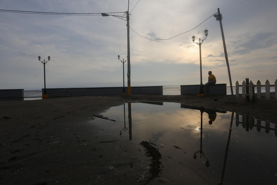 A man sits on the sea wall in the beach town of Ponelya, on the Pacific coast of Nicarauga, Tuesday, Sept. 11, 2018. Nicaragua's economy has been devastated by the nearly five months of unrest sparked by cuts to social security benefits that quickly evolved into calls for President Daniel Ortega to step down. (AP Photo/Alfredo Zuniga)