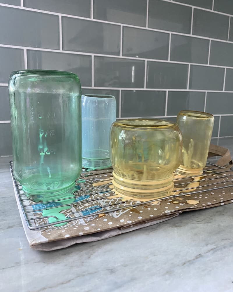 DIY vintage colored glass jars drying on rack, close to being done