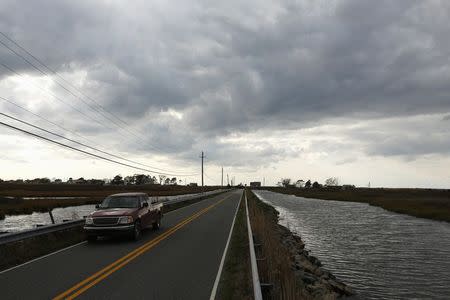 A pickup truck travels on the only access road to Saxis Island, a historic fishing village on Virginia's Eastern Shore October 25, 2013. REUTERS/Kevin Lamarque