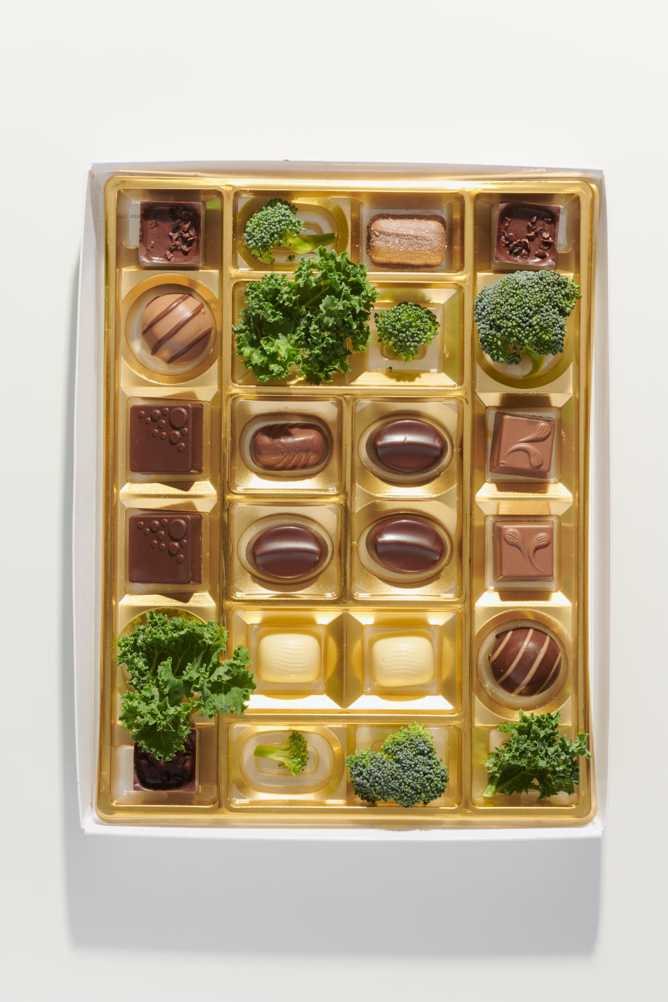 Una caja de chocolates con algunos trozos de col rizada y brócoli, en Los Ángeles, el 7 de julio de 2022. (Aileen Son/The New York Times)
