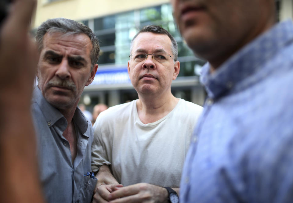 FILE - In this Wednesday, July 25, 2018 file photo, Andrew Craig Brunson, centre, an evangelical pastor from Black Mountain, North Carolina, who had been jailed in Turkey for more than one and a half years on terror and espionage charges, arrives at his house in Izmir, Turkey where he was put under house arrest as his trial continues. Turkey's arrests of Brunson and other Western citizens have thrust its troubled judicial system to the forefront of ties with allies, reinforcing suspicions that the Turkish government is using detainees as diplomatic leverage. (AP Photo/Emre Tazegul, File)