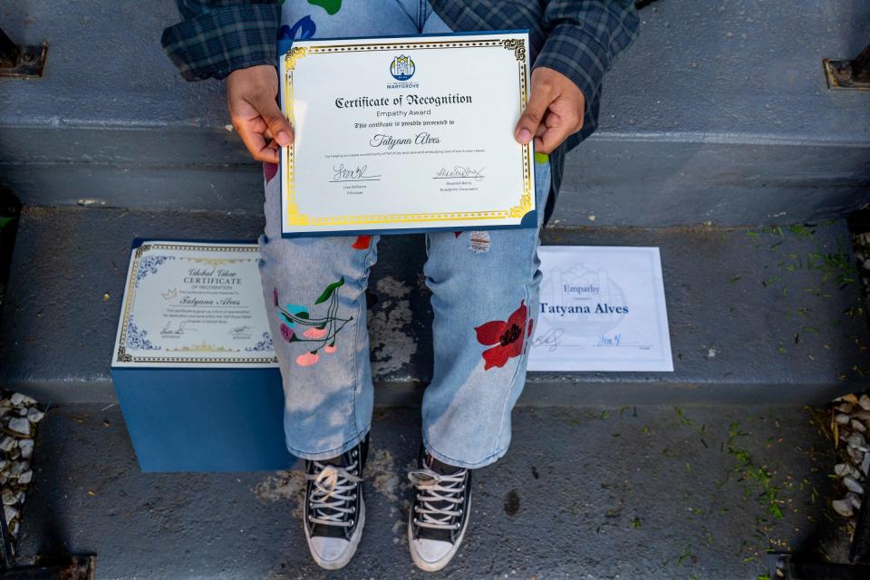 The School at Marygrove senior Tatyana Alves, 17, shows some of the awards she was given from her school while sitting on the front porch of her home in Detroit on Wednesday, May 17, 2023. Alves, who is a part of the first high school graduating class at The School at Marygrove in Detroit, has received more than $1.7 million in scholarships. She was voted u0022Most Positiveu0022 in her historic graduating class, and she credits her positivity and selflessness, qualities she learned from her mother for her high school success.