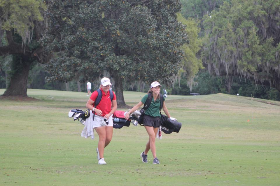 Savannah Christian's Mary Miller (left) and Savannah Country Day's Kate Barber share a laugh walking up a fairway at Bacon Park Golf Course during the Savannah City High School Championship on April 2, 2024.