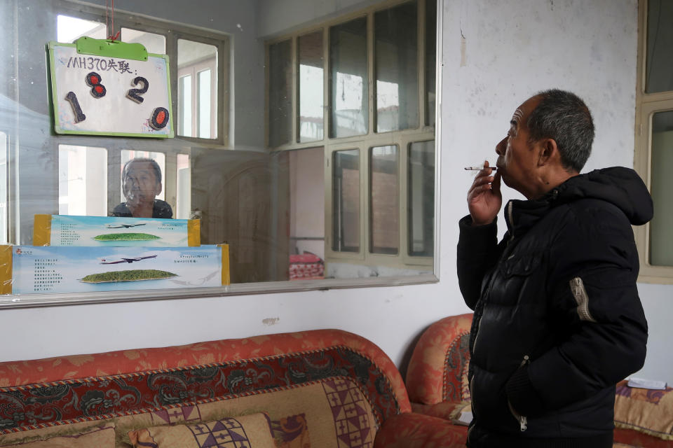 Li Eryou, whose son Li Yanlin was on the Malaysia Airlines flight MH370 that disappeared on March 8, 2014, poses in front of a sign marking the number of days his son went missing, during a Reuters interview at his house in Handan, Hebei province, China March 1, 2019. Picture taken March 1, 2019. REUTERS/Joyce Zhou