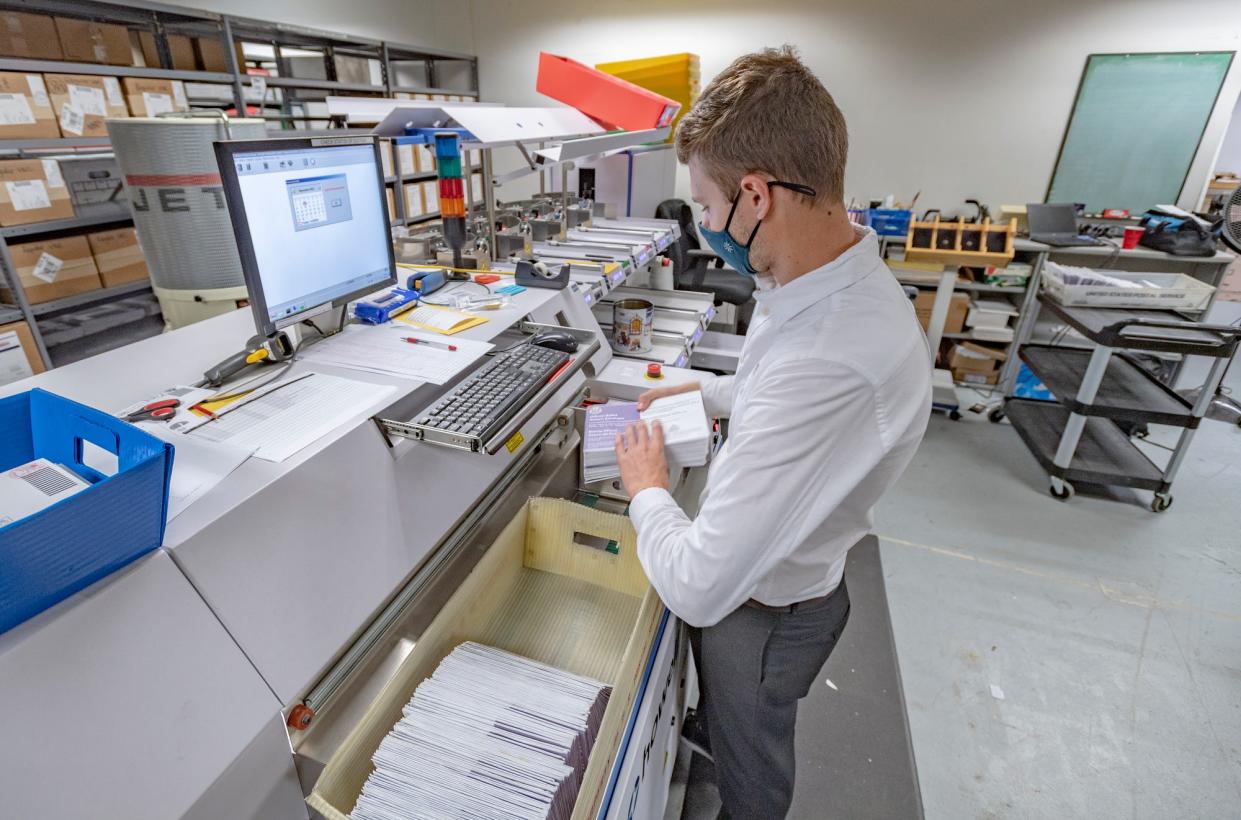 Devin Craycraft operates runs ballots for signature verification at the Tulare County Elections Office on Tuesday, November 3, 2020. It is the first step in processing a ballot even before it is opened.