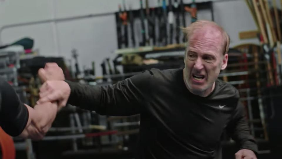 Bob Odenkirk in a black shirt throws a paunch during a training session for Nobody.