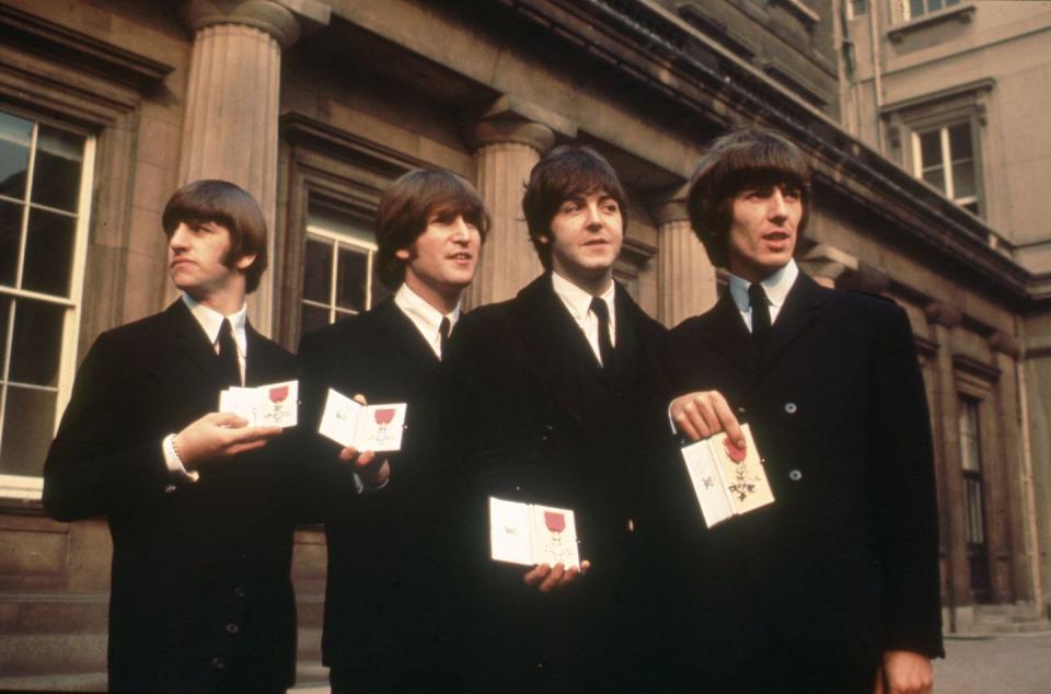 <p>Even though this wasn’t The Beatles’ first time meeting the Queen (they performed for her in 1963 and John Lennon famously told her to “<a href="https://www.youtube.com/watch?v=rvBCmY7wAAU" rel="nofollow noopener" target="_blank" data-ylk="slk:just rattle your jewelry;elm:context_link;itc:0;sec:content-canvas" class="link ">just rattle your jewelry</a>” while they played “Twist and Shout”), this was the most honorable occasion. The Queen awarded them The Most Excellent Order of the British Empire (OBE) in 1965 and they sported classic black suits for the event, naturally.</p>