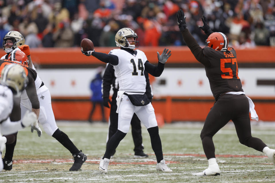 New Orleans Saints quarterback Andy Dalton (14) is pressured by Cleveland Browns defensive tackle Ben Stille (57) during the first half of an NFL football game, Saturday, Dec. 24, 2022, in Cleveland. (AP Photo/Ron Schwane)