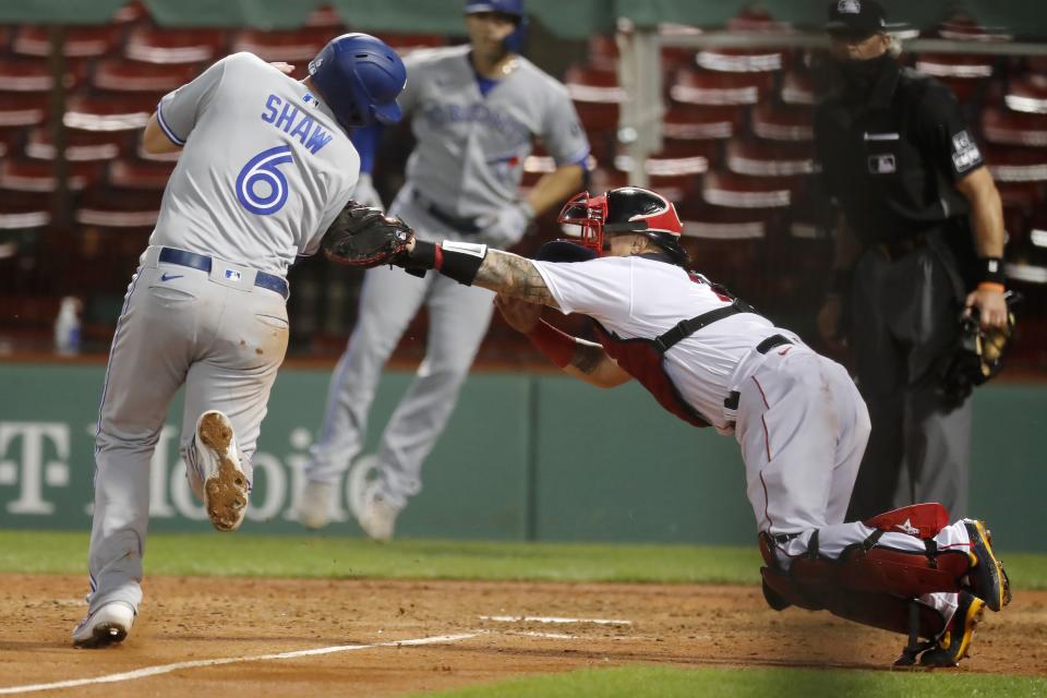 Boston Red Sox's Christian Vazquez tags out Toronto Blue Jays' Travis Shaw (6) at home plate during the sixth inning of a baseball game, Saturday, Aug. 8, 2020, in Boston. (AP Photo/Michael Dwyer)