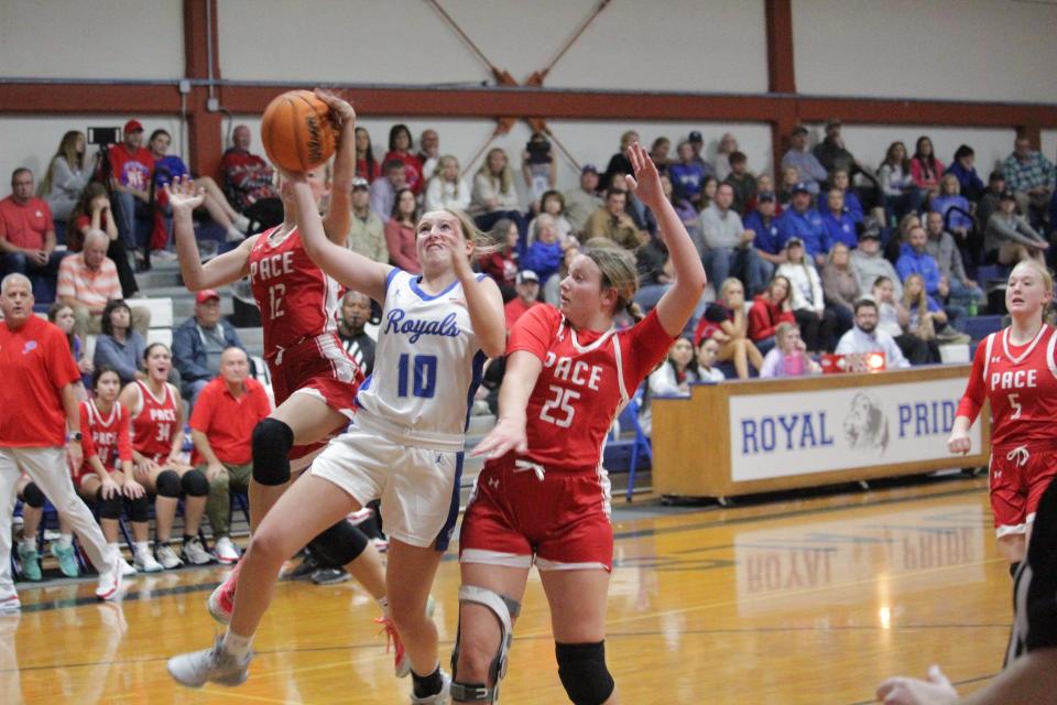 Jay's Presley Hawthorne (10) drives toward the hoop against a couple Pace defenders during the Royals' 45-32 win over the Patriots on Thursday, Dec. 14, 2023, in Jay.