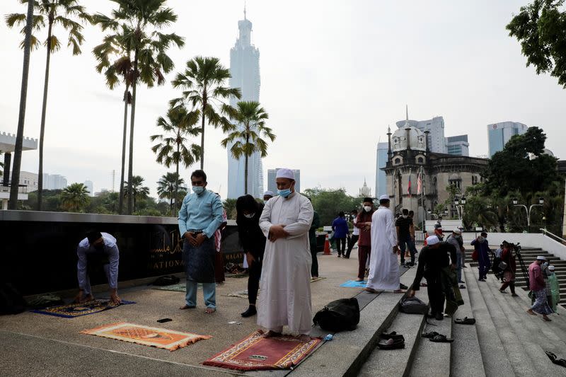 Muslims disperse after they were warned by police officers outside the closed National Mosque while celebrating Eid al-Fitr amid the coronavirus disease (COVID-19) outbreak in Kuala Lumpur