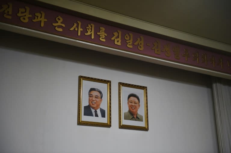 Portraits of late North Korean leaders Kim Il-Sung (L) and Kim Jong-Il hang on a wall at the North Korean embassy in Beijing on July 28, 2015