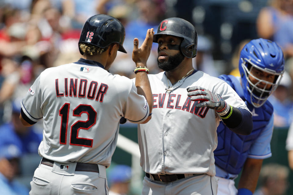 Cleveland Indians' Carlos Santana, center, is congratulated by Francisco Lindor, left, after hitting a three-run home run against the Kansas City Royals in the first inning of a baseball game at Kauffman Stadium in Kansas City, Mo., Sunday, July 28, 2019. Looking on is Royals catcher Meibrys Viloria, right. (AP Photo/Colin E. Braley)