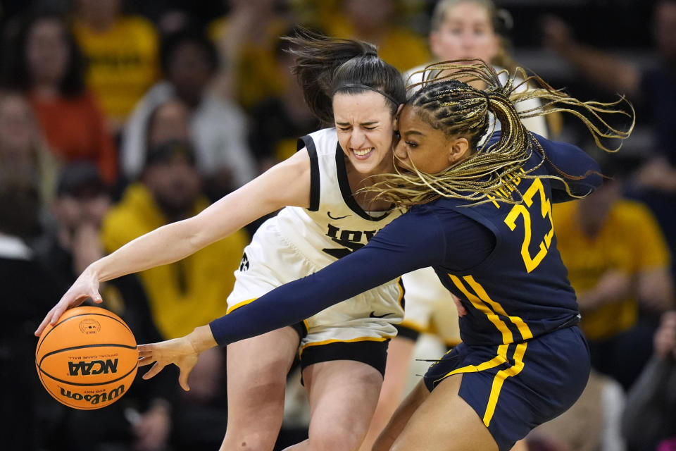 West Virginia guard Lauren Fields (23) tries to steal the ball from Iowa guard Caitlin Clark in the first half of a second-round college basketball game in the NCAA Tournament, Monday, March 25, 2024, in Iowa City, Iowa. (AP Photo/Charlie Neibergall)