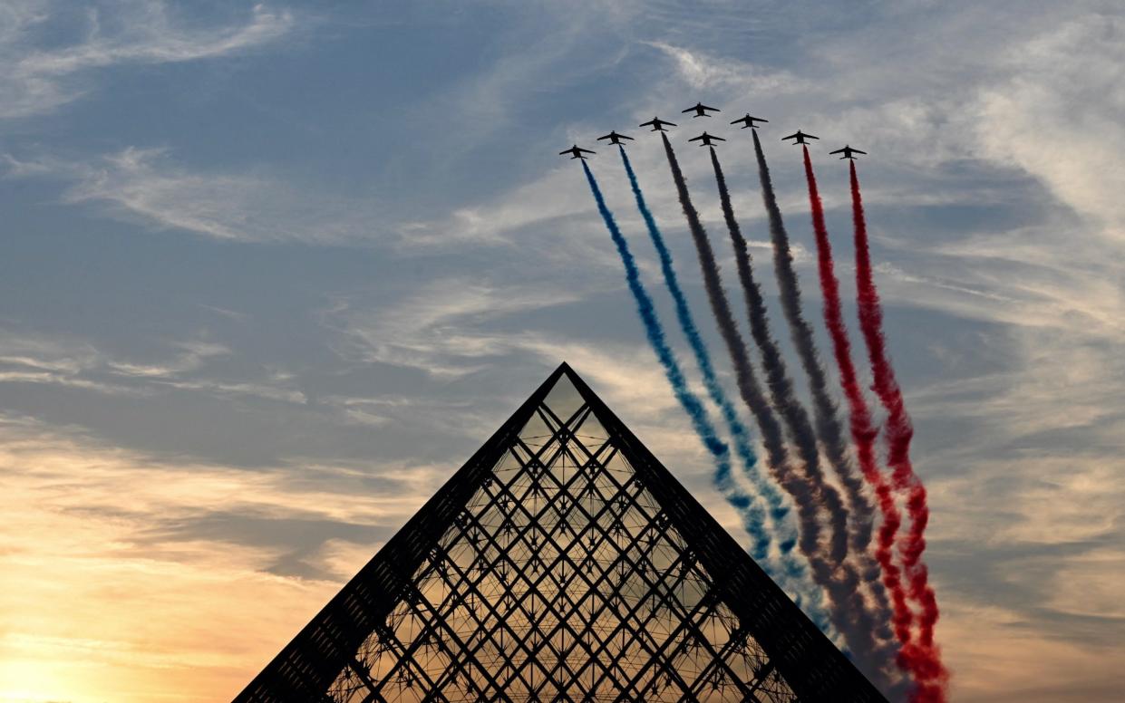 French Air Force Elite acrobatic flying team "Patrouille de France" performs over the Pyramide du Louvre designed by Chinese-US architect Ieoh Ming Pei, during the Paris 2024 Paralympic Games Opening Ceremony in Paris