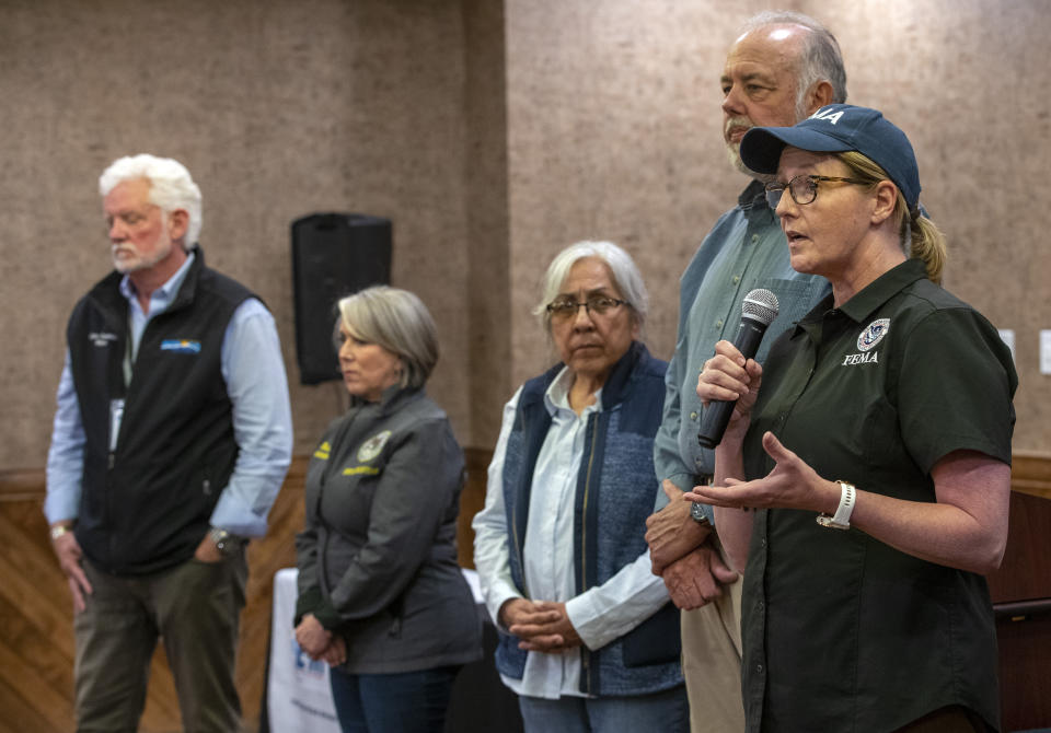 FEMA administrator Deanne Criswell, far right, accompanied by local officials including New Mexico Gov. Michelle Lujan Grisham, second from left, speaks during a media briefing in the mountain village of Ruidoso, N.M., Saturday, June 22, 2024. Recent rains and cooler weather are helping firefighters gain ground on two wildfires in southern New Mexico. (AP Photo/Andres Leighton)