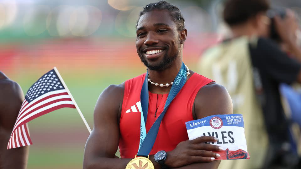 Lyles poses with the flag and his gold medal after the race. - Patrick Smith/Getty Images