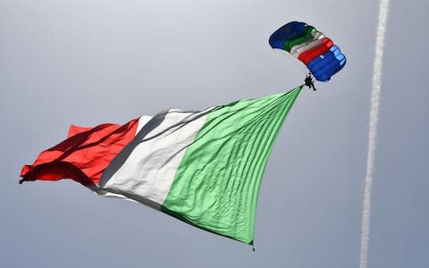 An Italian Army parachutist flies the Italian national flag during a ceremony marking the anniversary of the Italian Republic (Republic Day) - Credit: ALBERTO PIZZOLI/AFP