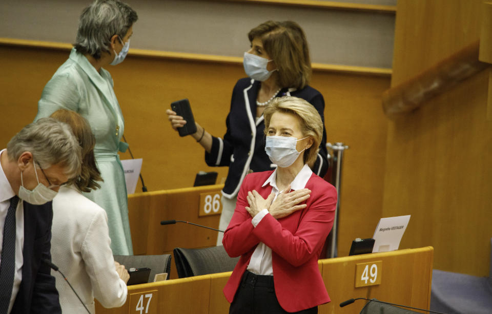 European Commission President Ursula von der Leyen, right, gestures hello to an MEP prior to addressing the European Parliament plenary in Brussels, Wednesday, May 27, 2020. The European Union is to unveil Wednesday a massive coronavirus recovery plan worth hundreds of billions of euros to help countries rebuild their ailing economies, but the bloc remains deeply divided over what conditions should be attached to the funds. (AP Photo/Olivier Matthys)