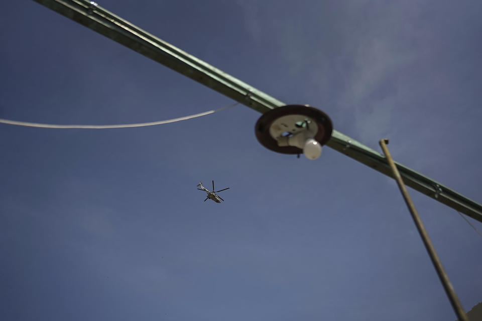 A Mexican Navy helicopter flies over the home of Estela Sandoval Diaz which was destroyed by the Hurricane Otis, including ripping off her tin roof, in Acapulco, Mexico, Friday, Oct. 27, 2023. Sandoval was among hundreds of thousands of people whose lives were torn apart when the fastest intensifying hurricane on record in the Eastern Pacific shredded the coastal city of 1 million. (AP Photo/Felix Marquez)