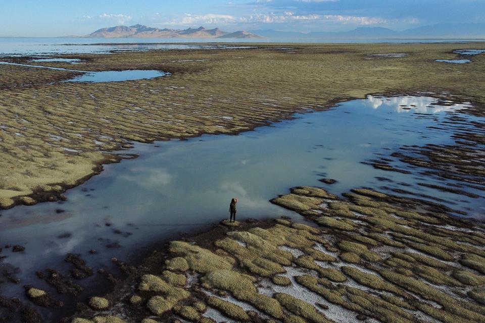State of Utah Department of Natural Resources park ranger Angelic Lemmon walks across reef-like structures called microbialites, exposed by receding waters, at the Great Salt Lake, near Salt Lake City, on Sept. 28, 2022.