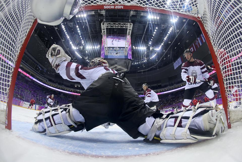 Latvia goaltender Edgars Masalskis snags a shot on goal by Switzerland in the second period of a men's ice hockey game at the 2014 Winter Olympics, Tuesday, Feb. 18, 2014, in Sochi, Russia. (AP Photo/Bruce Bennett, Pool)