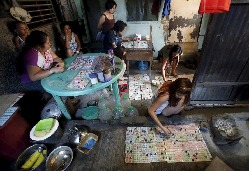 Women play bingo inside a house in Quezon City, Metro Manila, Philippines March 1, 2015. Bingo, both legal and illegal, is one of the more popular forms of sports betting in the Philippines, attracting rich and poor alike. When paying your final respects for a relative or friend, the last thing you might expect to see at the wake is people placing bets on a card game or bingo. Not in the Philippines. Filipinos, like many Asians, love their gambling. But making wagers on games such as "sakla", the local version of Spanish tarot cards, is particularly common at wakes because the family of the deceased gets a share of the winnings to help cover funeral expenses. Authorities have sought to regulate betting but illegal games persist, with men and women, rich and poor, betting on anything from cockfighting to the Basque hard-rubber ball game of jai-alai, basketball to spider races. Many told Reuters photographer Erik De Castro that gambling is only an entertaining diversion in a country where two-fifths of the population live on $2 a day. But he found that some gamble every day. Casino security personnel told of customers begging to be banned from the premises, while a financier who lends gamblers money at high interest described the dozens of vehicles and wads of land titles given as collateral by those hoping lady luck would bring them riches. REUTERS/Erik De Castro PICTURE 20 OF 29 FOR WIDER IMAGE STORY "HIGH STAKES IN MANILA". SEARCH "BINGO ERIK" FOR ALL IMAGES.