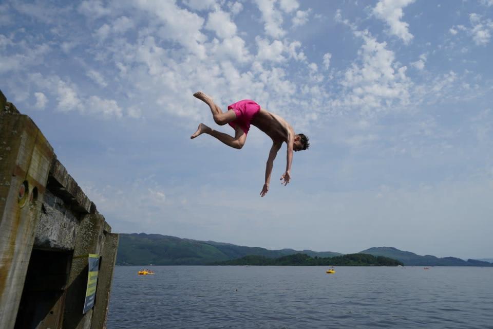 People jump from a pier into the water of Loch Lomond (Andrew Milligan/PA) (PA Wire)