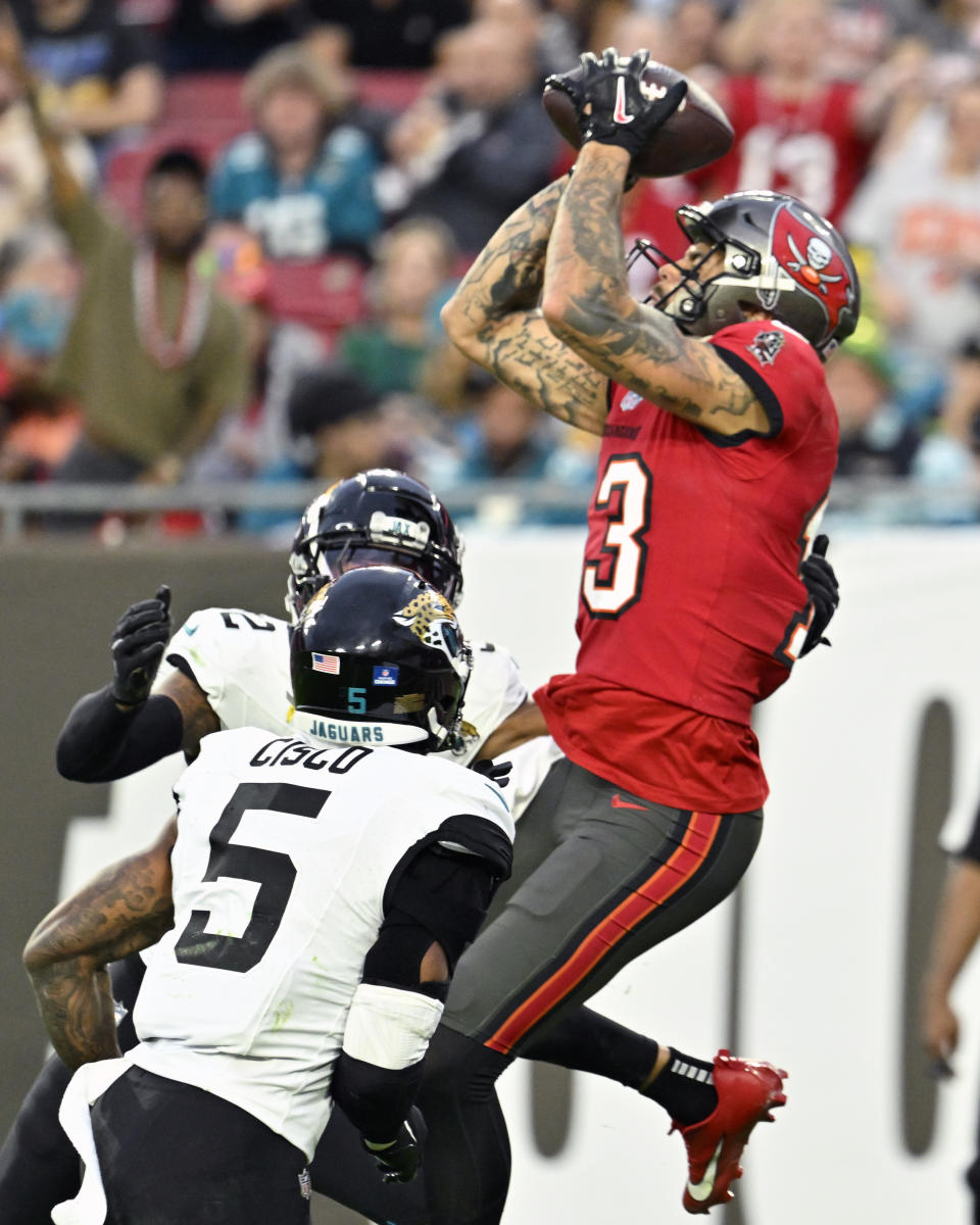 Tampa Bay Buccaneers wide receiver Mike Evans, right, makes a touchdown reception over Jacksonville Jaguars safety Andre Cisco (5) for a 22-yard pass play during the first half of an NFL football game Sunday, Dec. 24, 2023, in Tampa, Fla. (AP Photo/Jason Behnken)