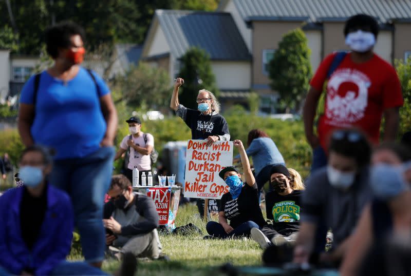 People rally for the defunding of police and reinvestment in community before marching to Seattle Mayor Durkan's home in Seattle