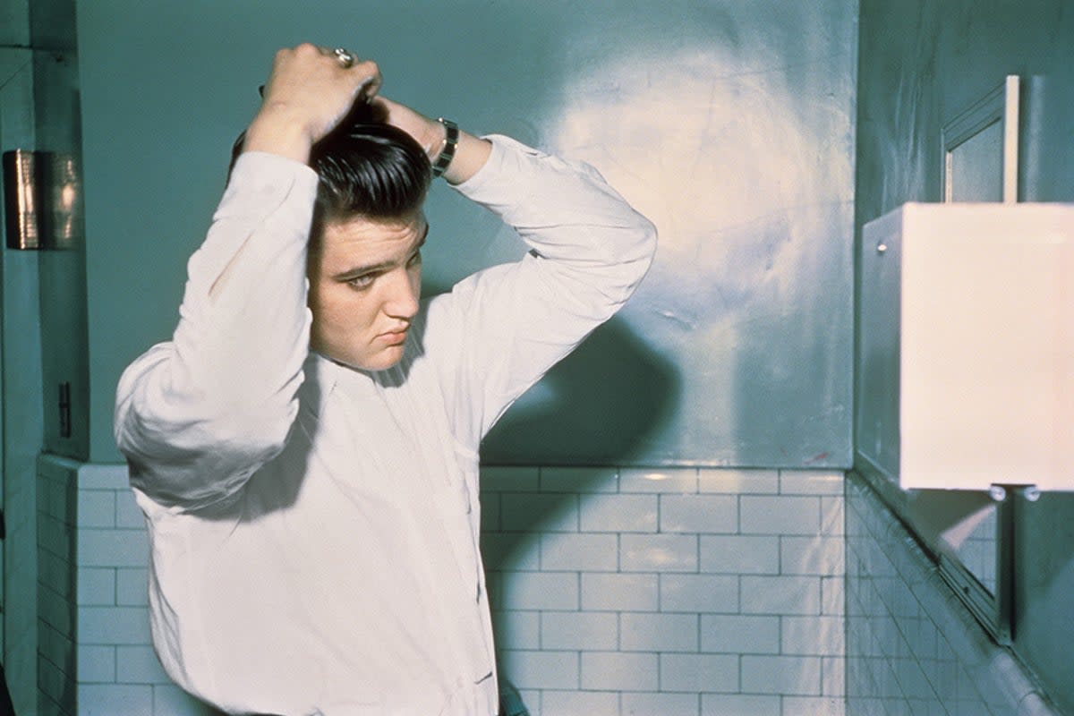 Elvis tending to his pompadour in the men’s room of the Mosque Theater, Richmond, Virginia, 30 June 1956  (Alfred Wertheimer/Courtesy Taschen)