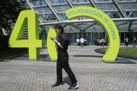 A woman walks past a sign marking Volkswagen's 40 years (in China) in Beijing, Wednesday, April 24, 2024. Foreign automakers have been caught flat-footed in China by an electric vehicle boom that has shaken up the market over the last three years. That has left manufacturers like Volkswagen scrambling to develop new models for a very different market than at home. (AP Photo/Ng Han Guan)