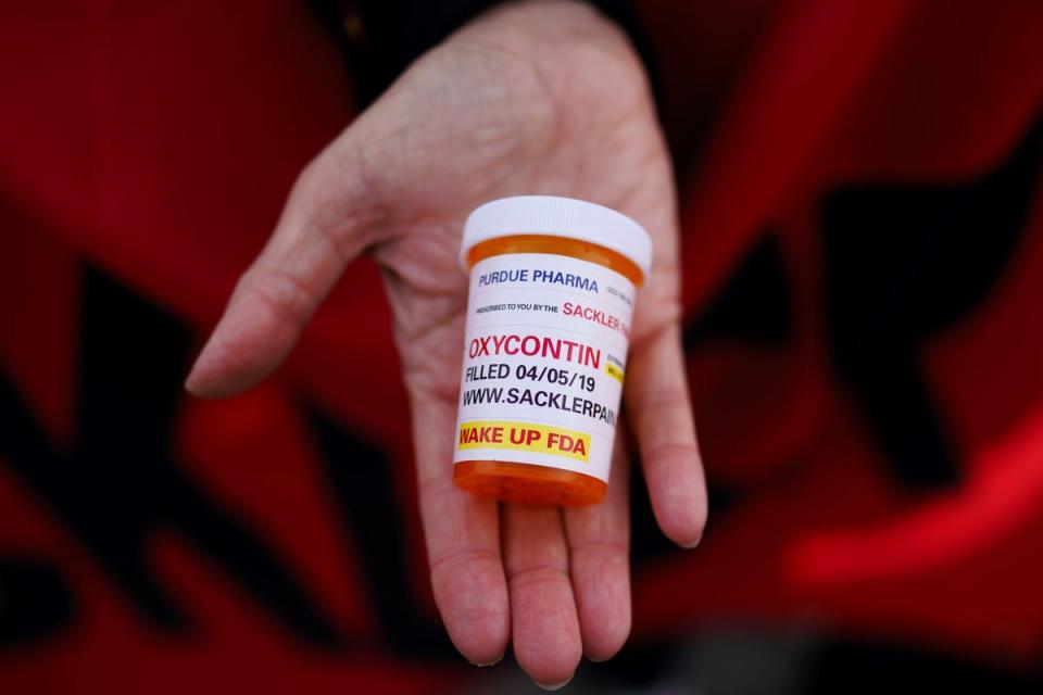 A campaigner holds a pill container whilst outside the US Supreme Court, Washington, DC, USA, 04 December 2023. The US Supreme Court is hearing oral arguments in a bankruptcy case against Purdue Pharma, the makers of OxyContin (EPA)