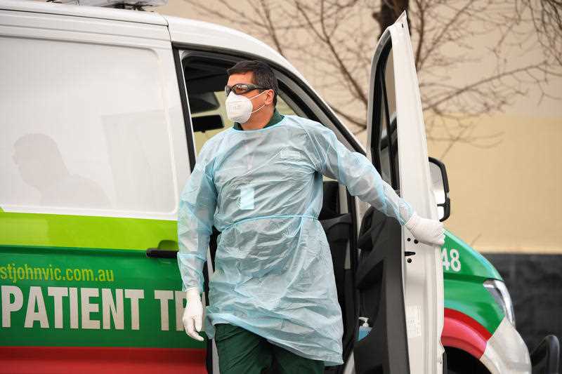 A healthcare worker arrives to remove a resident of Hambleton House into a patient transport vehicle in Melbourne.